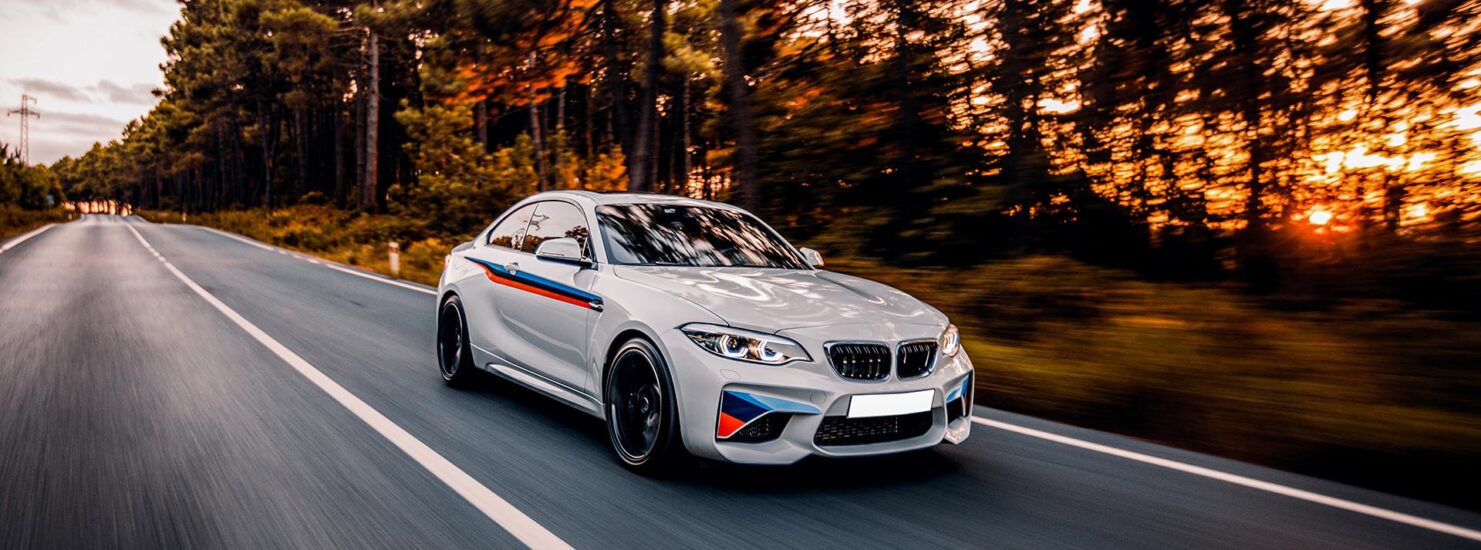 sedan-white-driving-road