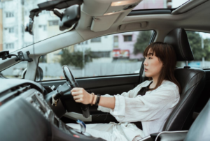 woman wearing white driving a car